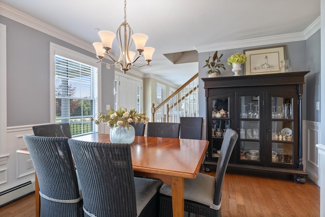 42 Snowberry Dr, Gorham, ME 04038 - dining area with a baseboard heating unit, a chandelier, ornamental molding, wood finished floors, and stairs