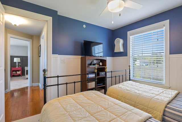 42 Snowberry Dr, Gorham, ME 04038 - bedroom featuring wood finished floors, wainscoting, a ceiling fan, and a decorative wall