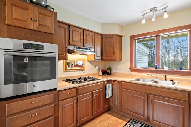447 Wiscasset Rd, Boothbay, ME 04537 - kitchen featuring stainless steel oven, a sink, under cabinet range hood, black gas cooktop, and brown cabinetry