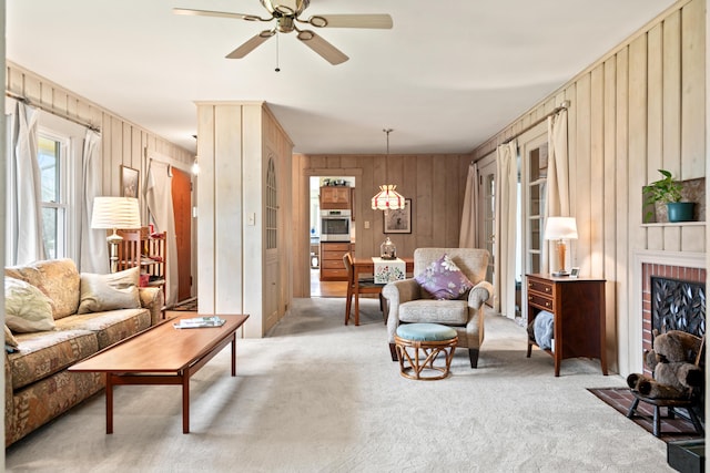 447 Wiscasset Rd, Boothbay, ME 04537 - living area featuring carpet flooring, wooden walls, ceiling fan, and a brick fireplace