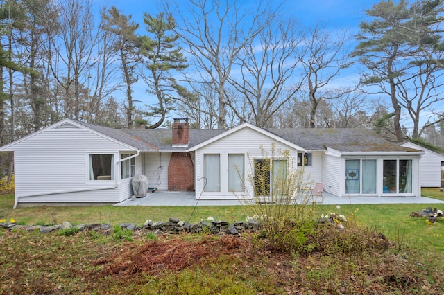 447 Wiscasset Rd, Boothbay, ME 04537 - rear view of house with a patio, a chimney, and a lawn