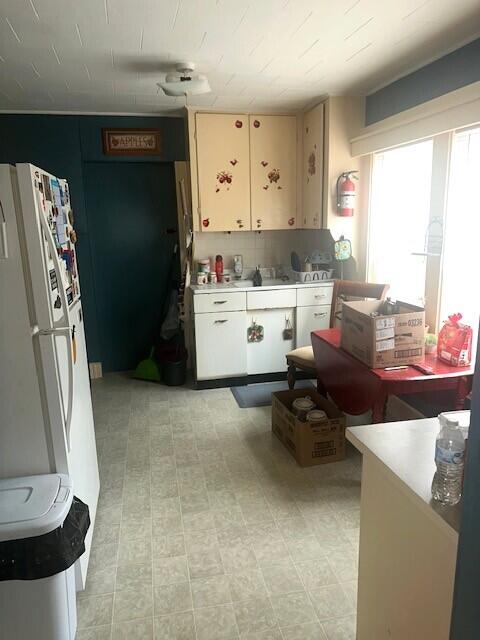 627 Prospect Ave, Rumford, ME 04276 - kitchen with light countertops, white cabinetry, and freestanding refrigerator