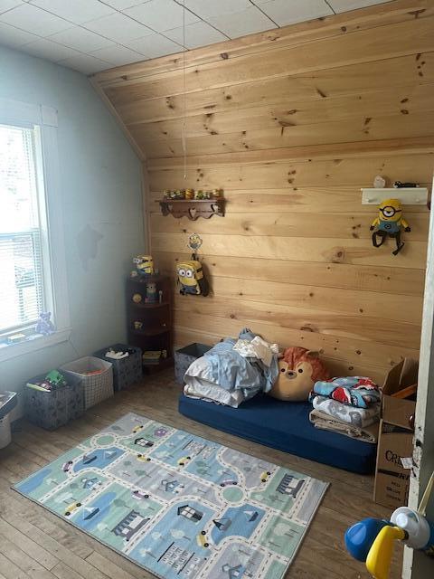 627 Prospect Ave, Rumford, ME 04276 - bedroom with hardwood / wood-style flooring, vaulted ceiling, and wood walls
