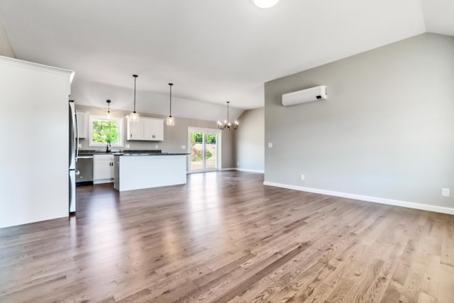 LOT11 Laney Ln, Wells, ME 04090 - unfurnished living room with vaulted ceiling, a chandelier, wood finished floors, a wall unit AC, and baseboards