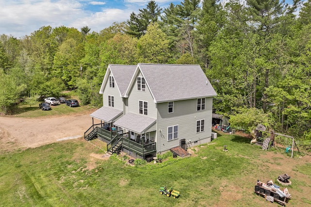 28-30 W Winds Dr, Lebanon, ME 04027 - rear view of house featuring a shingled roof, dirt driveway, a deck, a lawn, and a view of trees