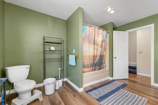 28-30 W Winds Dr, Lebanon, ME 04027 - bathroom with wood finished floors, a shower with curtain, baseboards, and toilet