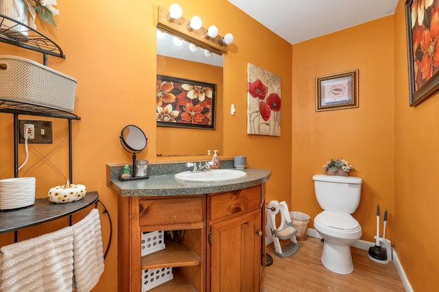 28-30 W Winds Dr, Lebanon, ME 04027 - bathroom with wood finished floors, toilet, vanity, and baseboards