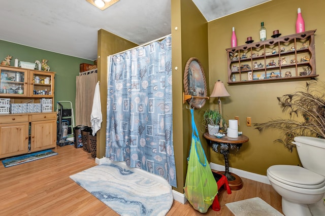28-30 W Winds Dr, Lebanon, ME 04027 - full bathroom with wood finished floors, toilet, a shower with shower curtain, and baseboards