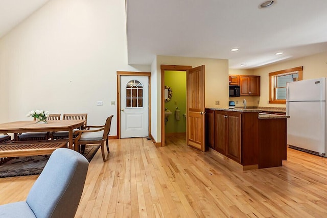 202 Wildewood Ests, Rome, ME 04963 - kitchen featuring freestanding refrigerator, black microwave, light wood finished floors, brown cabinetry, and a peninsula