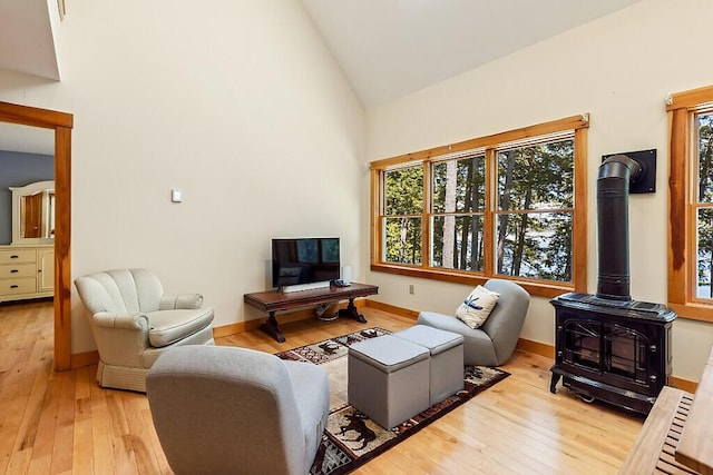 202 Wildewood Ests, Rome, ME 04963 - living room with a wood stove, wood-type flooring, plenty of natural light, and high vaulted ceiling