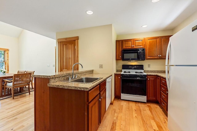 202 Wildewood Ests, Rome, ME 04963 - kitchen with black microwave, freestanding refrigerator, gas stove, a sink, and a peninsula