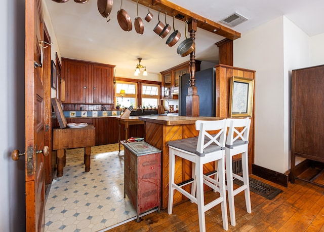 15 Federal St, Bar Harbor, ME 04609 - kitchen featuring black refrigerator, a kitchen breakfast bar, a peninsula, and wood-type flooring