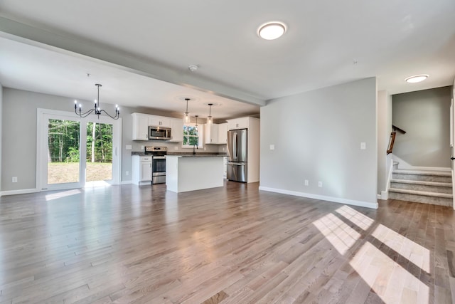 LOT10 Laney Ln, Wells, ME 04090 - unfurnished living room featuring a chandelier, baseboards, wood finished floors, a sink, and stairs