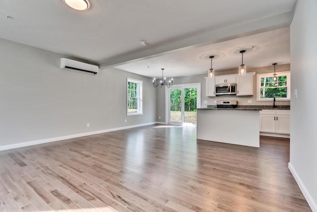 LOT10 Laney Ln, Wells, ME 04090 - kitchen with an AC wall unit, appliances with stainless steel finishes, white cabinetry, open floor plan, and wood finished floors