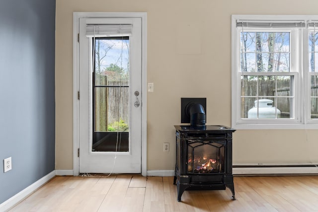 entryway featuring a baseboard radiator, wood finished floors, and baseboards