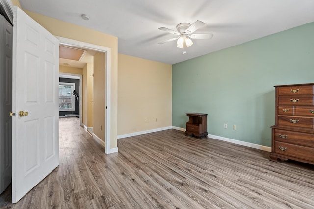 empty room with wood finished floors, ceiling fan, and baseboards
