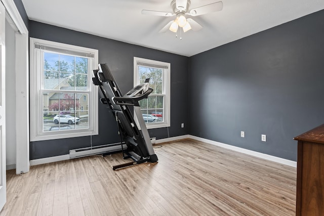 workout area with a ceiling fan, wood finished floors, baseboards, and baseboard heating