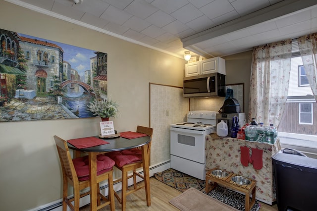 532 Main St, South Portland, ME 04106 - kitchen with stainless steel microwave, white electric stove, crown molding, light wood-type flooring, and a baseboard radiator