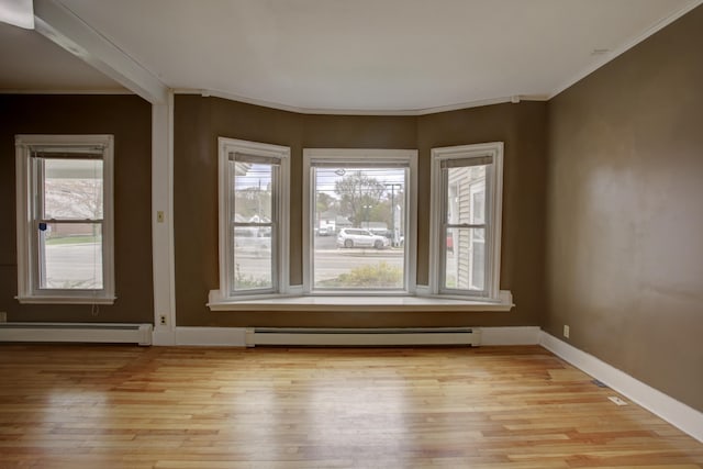 532 Main St, South Portland, ME 04106 - spare room with a baseboard heating unit, light wood-style flooring, ornamental molding, and baseboards