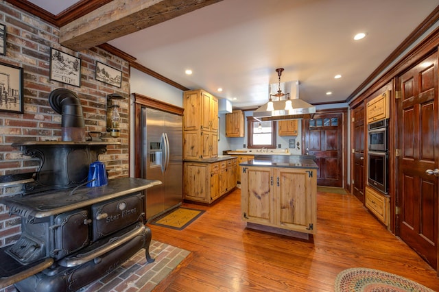 25 Winds Way Dr, Nobleboro, ME 04555 - kitchen featuring stainless steel appliances, a wood stove, crown molding, dark countertops, and a kitchen island