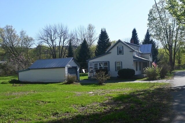 40 Baker St, Bingham, ME 04920 - view of home's exterior with an outbuilding, a lawn, and metal roof