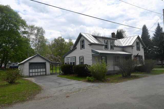 40 Baker St, Bingham, ME 04920 - view of side of home featuring a detached garage, a chimney, an outbuilding, metal roof, and a standing seam roof