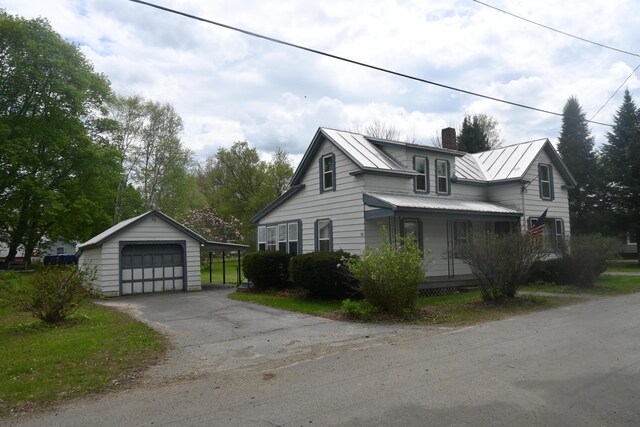 40 Baker St, Bingham, ME 04920 - view of property exterior featuring a detached garage, a chimney, an outbuilding, metal roof, and asphalt driveway