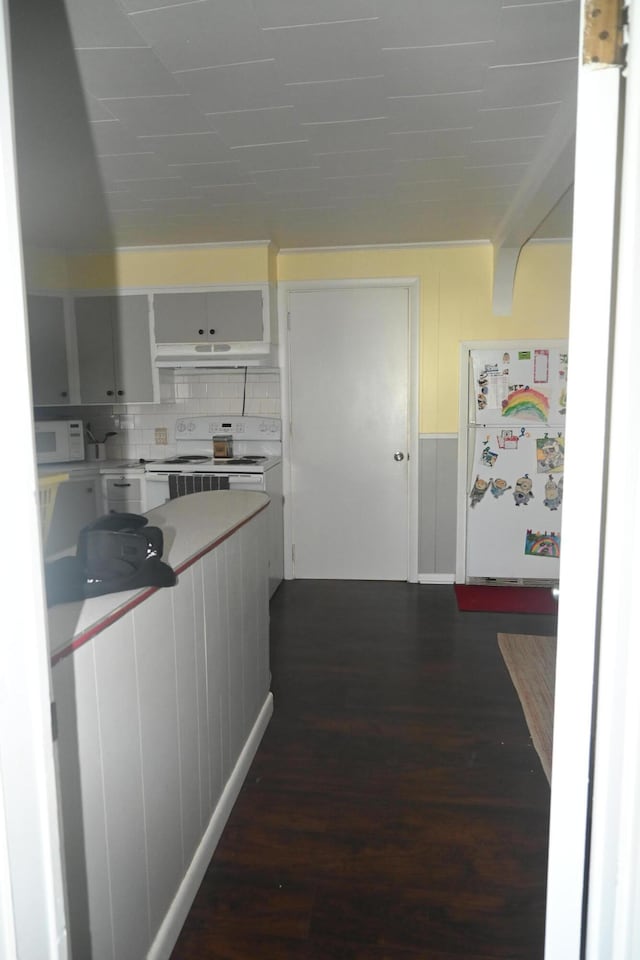 40 Baker St, Bingham, ME 04920 - kitchen with white appliances, light countertops, dark wood-type flooring, white cabinets, and decorative backsplash
