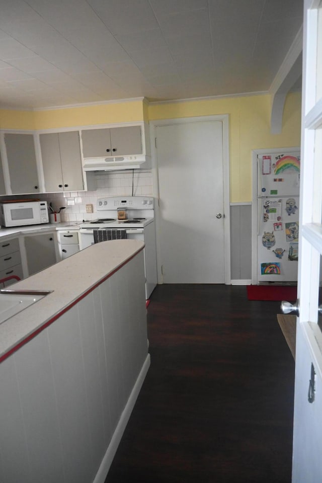40 Baker St, Bingham, ME 04920 - kitchen featuring white appliances, under cabinet range hood, light countertops, dark wood finished floors, and backsplash