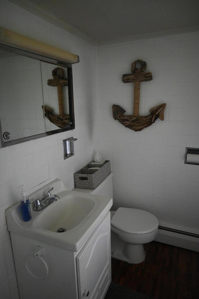 40 Baker St, Bingham, ME 04920 - bathroom featuring tile walls, a baseboard radiator, vanity, wood finished floors, and toilet