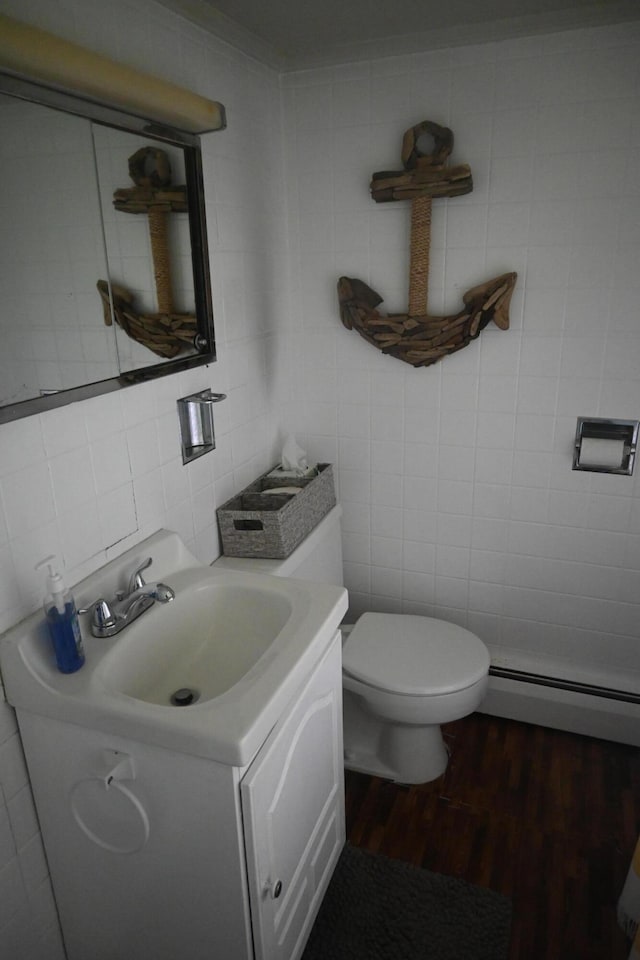 40 Baker St, Bingham, ME 04920 - half bath with tile walls, vanity, a baseboard heating unit, wood finished floors, and toilet