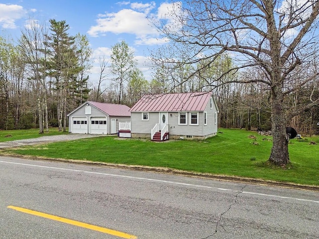 622 Waterville Rd, Unity, ME 04988 - view of front of house featuring a detached garage, an outdoor structure, entry steps, metal roof, and a front lawn