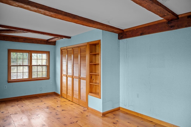 691 N Rd, Parsonsfield, ME 04047 - unfurnished bedroom with beam ceiling, light wood-style floors, baseboards, and a closet