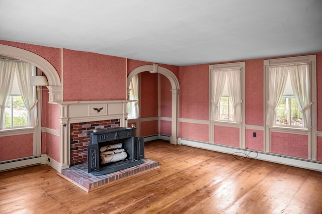 691 N Rd, Parsonsfield, ME 04047 - unfurnished living room with hardwood / wood-style floors, plenty of natural light, a baseboard radiator, and arched walkways