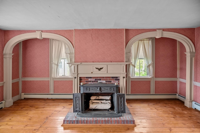 691 N Rd, Parsonsfield, ME 04047 - unfurnished living room with light wood-style flooring, a baseboard radiator, and arched walkways