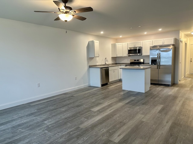 kitchen with stainless steel appliances, dark wood-style flooring, recessed lighting, a sink, and baseboards
