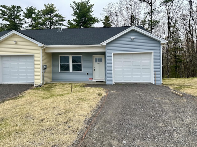 single story home with an attached garage, asphalt driveway, and a front lawn