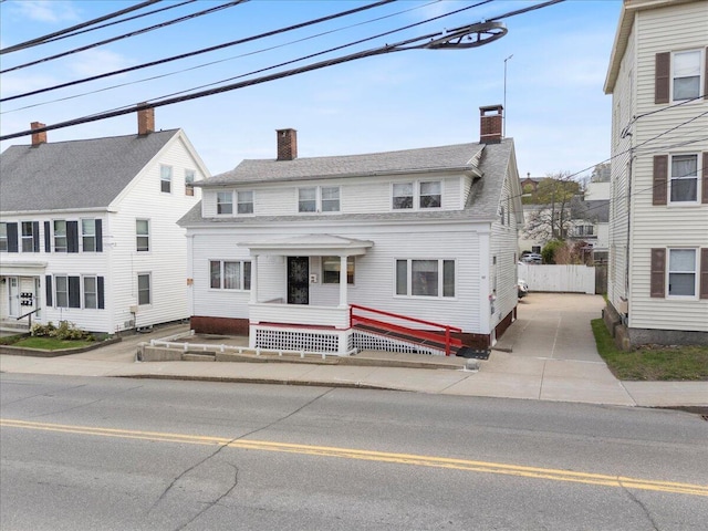 view of front of home with a chimney and fence