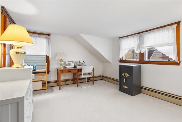 additional living space with healthy amount of natural light, light colored carpet, and a baseboard radiator