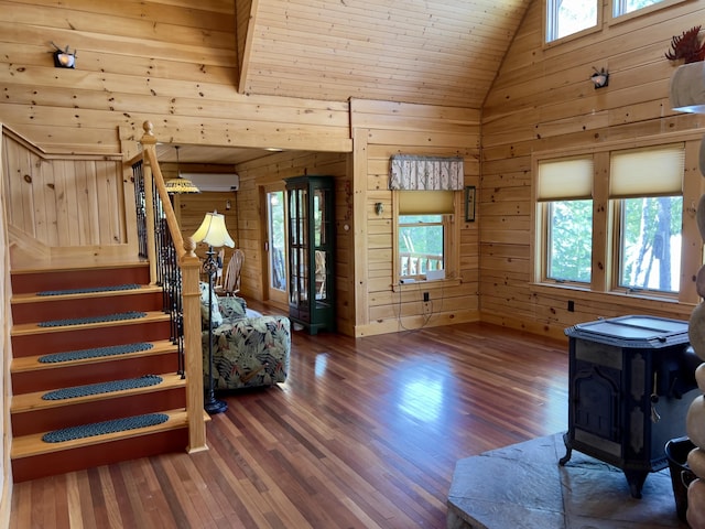 869 Turkey Tail Rd Unit T4, Indian Purchase Twp, ME 04462 - entrance foyer featuring a wood stove, wood walls, healthy amount of natural light, wood finished floors, and vaulted ceiling