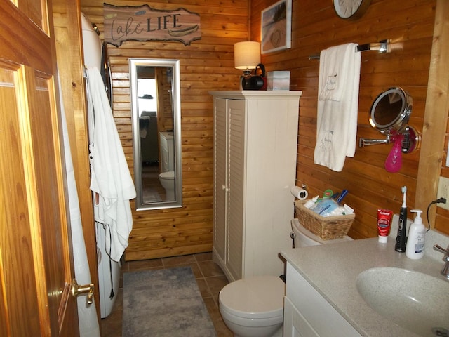 1824 Sunny Cove Ln, Meddybemps, ME 04657 - bathroom featuring tile patterned floors, vanity, toilet, and wooden walls