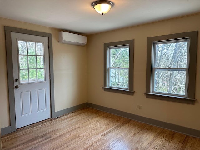 72 Seal Cove Rd, Southwest Harbor, ME 04679 - doorway to outside featuring a wall unit AC, light wood-style flooring, and baseboards