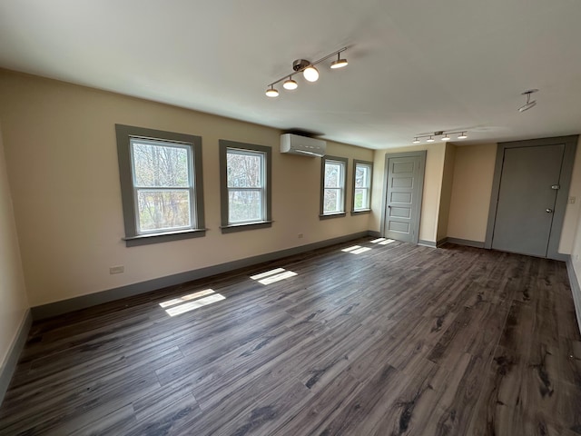 72 Seal Cove Rd, Southwest Harbor, ME 04679 - unfurnished room with a wall mounted air conditioner, rail lighting, and dark wood-type flooring