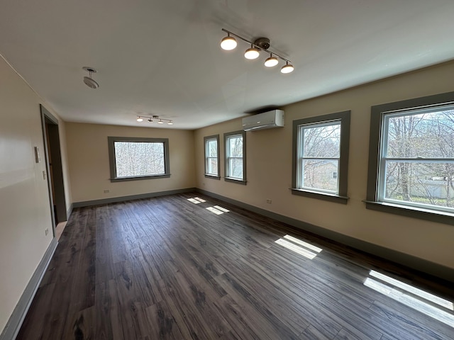 72 Seal Cove Rd, Southwest Harbor, ME 04679 - empty room with rail lighting, a wall mounted air conditioner, dark wood finished floors, and baseboards