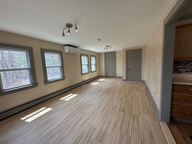 72 Seal Cove Rd, Southwest Harbor, ME 04679 - spare room with a wall unit AC, light wood finished floors, a baseboard heating unit, and baseboards
