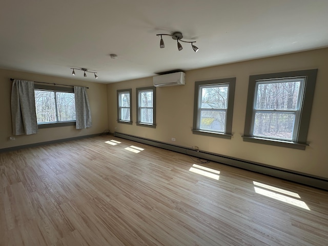 72 Seal Cove Rd, Southwest Harbor, ME 04679 - spare room with an AC wall unit, baseboard heating, light wood finished floors, and baseboards