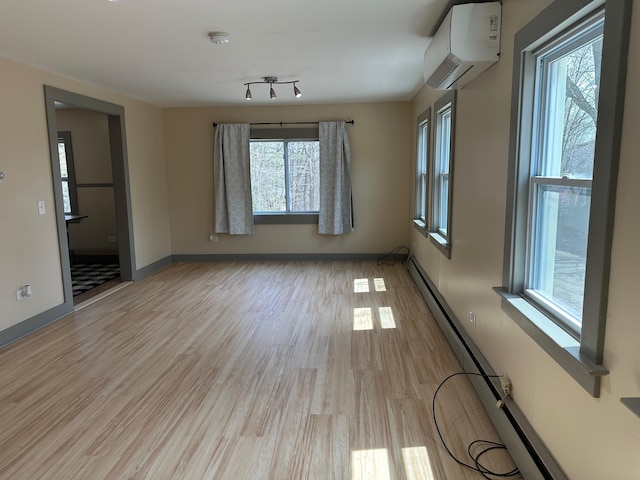 72 Seal Cove Rd, Southwest Harbor, ME 04679 - unfurnished room featuring a wall unit AC, a baseboard radiator, light wood-style flooring, and baseboards