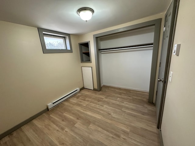 72 Seal Cove Rd, Southwest Harbor, ME 04679 - unfurnished bedroom with baseboard heating, wood finished floors, a closet, and baseboards