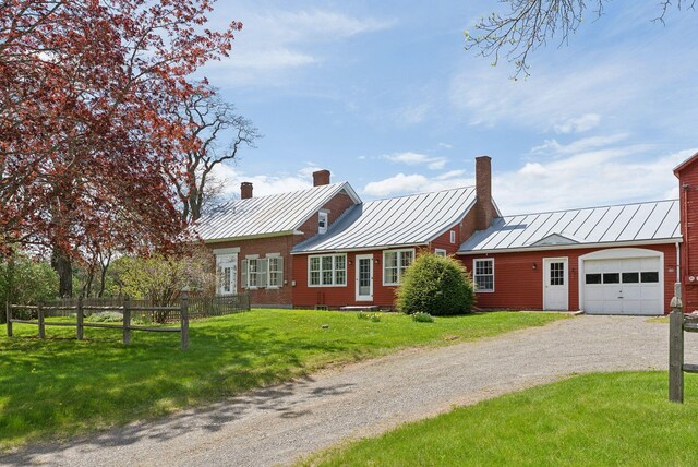 538 Malbons Mills Rd, Skowhegan, ME 04976 - view of front of property featuring a standing seam roof, a garage, a chimney, metal roof, and driveway