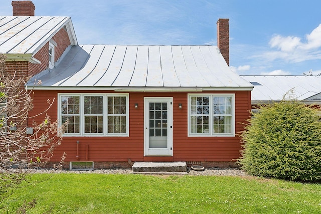 538 Malbons Mills Rd, Skowhegan, ME 04976 - view of front of house with a standing seam roof, a front lawn, a chimney, and metal roof